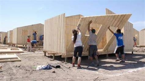 Voluntarios construyendo casas de emergencia