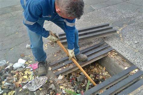 Operario limpiando una alcantarilla urbana