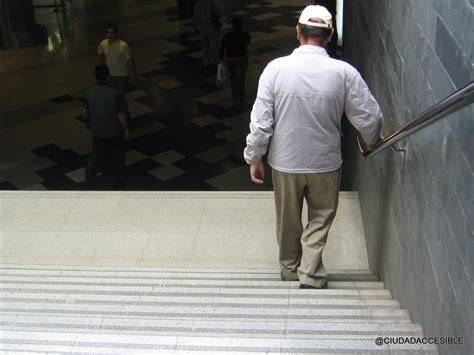 Persona usando pasamanos en escalera