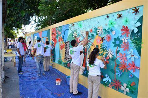 estudiantes pintando mural colaborativo escolar